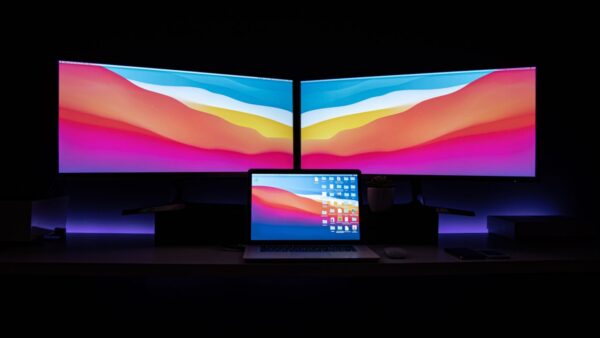 black flat screen tv turned on displaying blue and pink