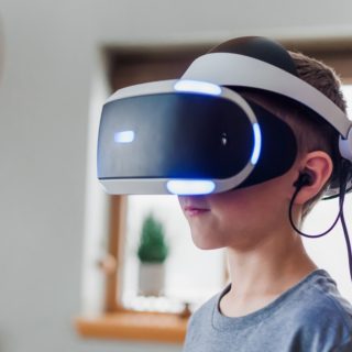 boy wearing black and white VR headset
