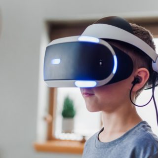 boy wearing black and white VR headset
